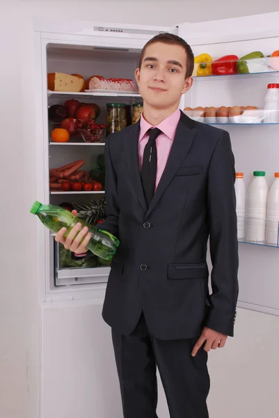 Tiener jongen in pak en stropdas in de buurt van de koelkast — Stockfoto