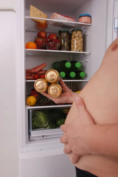 Homme tenir trois boîtes de bière sur le fond du réfrigérateur . — Photo