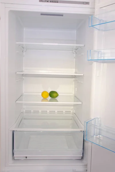 Citrusové plody v otevřených prázdná lednice. — Stock fotografie