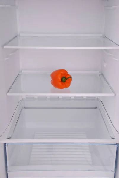 One pepper in open empty refrigerator. — Stock Photo, Image