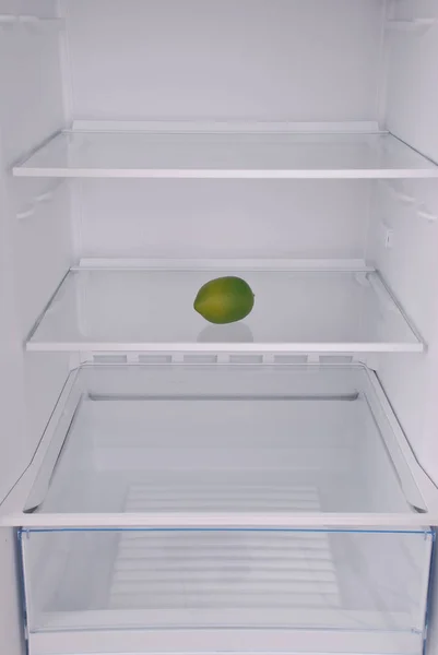 Ένα λεμόνι στο ανοιχτό άδειο ψυγείο. — Φωτογραφία Αρχείου