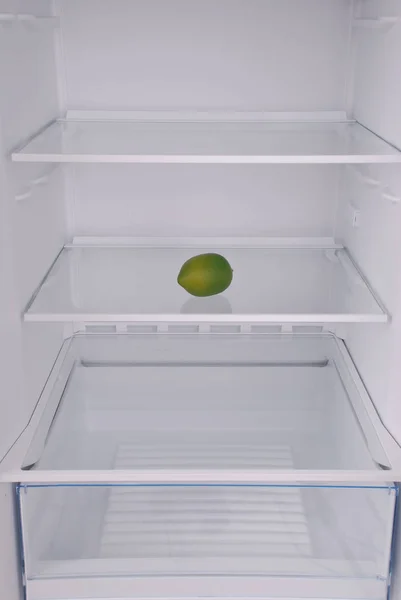 Un limón en el refrigerador vacío abierto . — Foto de Stock