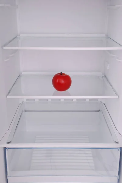 One apple in open empty refrigerator. — Stock Photo, Image