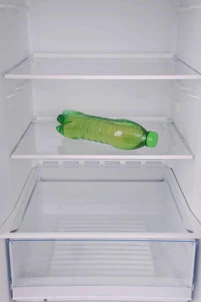 Láhev šťávy uvnitř prázdné čisté chladničky — Stock fotografie