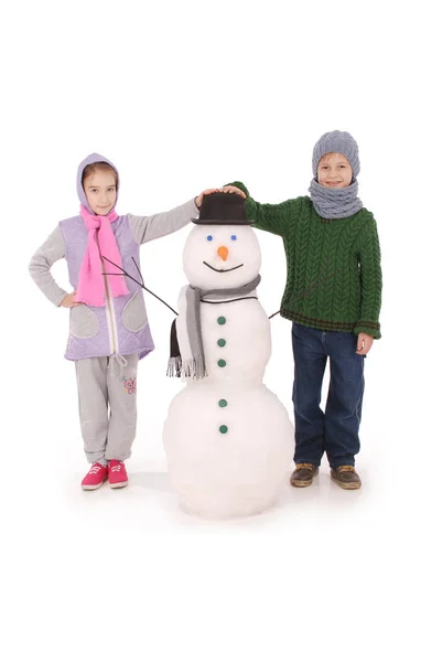 Lindo chico y chica con muñeco de nieve con bufanda y sombrero — Foto de Stock