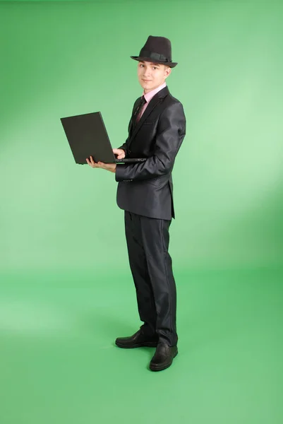 Homem de terno preto com um laptop — Fotografia de Stock