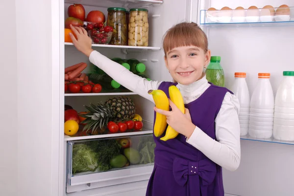 Menina bonita perto da geladeira com comida saudável . — Fotografia de Stock