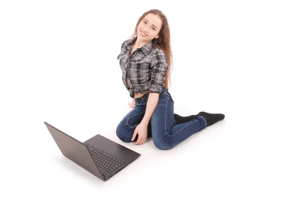 Młoda dziewczyna siedzi i za pomocą laptopa — Zdjęcie stockowe