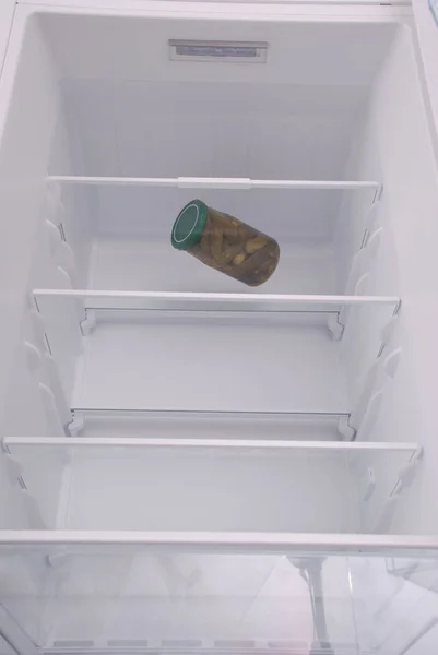 Pickled cucumbers inside in empty clean refrigerator