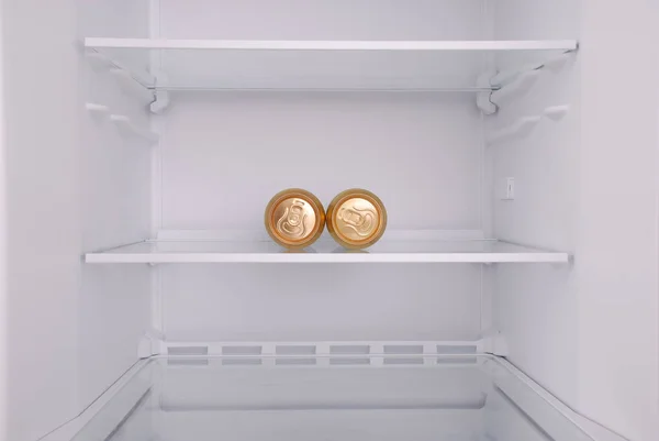 Twee metalen bierblikjes binnen in lege schone koelkast — Stockfoto