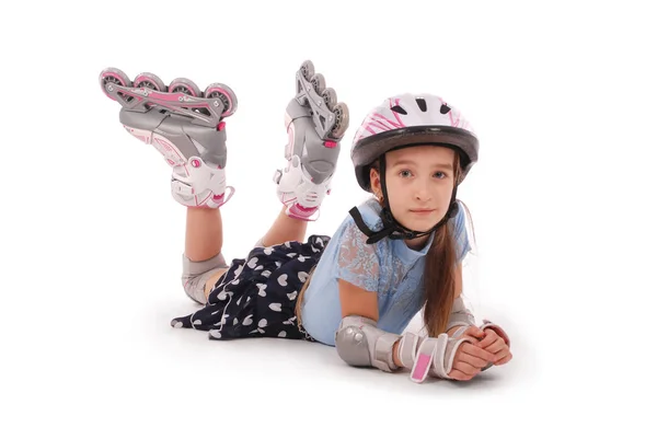 Niña feliz con patines y equipo de protección tirado en el suelo — Foto de Stock