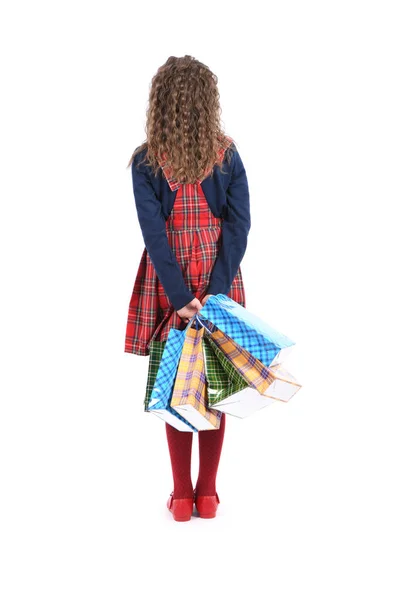 Criança com uma embalagem de textura quadriculada isolada sobre fundo branco. A menina gosta de fazer compras na temporada de venda. Presente de férias, compras . — Fotografia de Stock