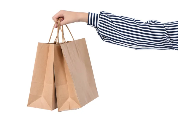 Kinderhandjes met papieren boodschappentassen geïsoleerd op wit — Stockfoto