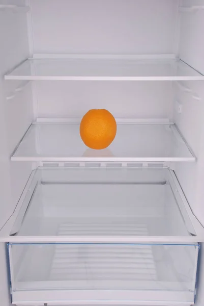 One orange in open empty refrigerator.