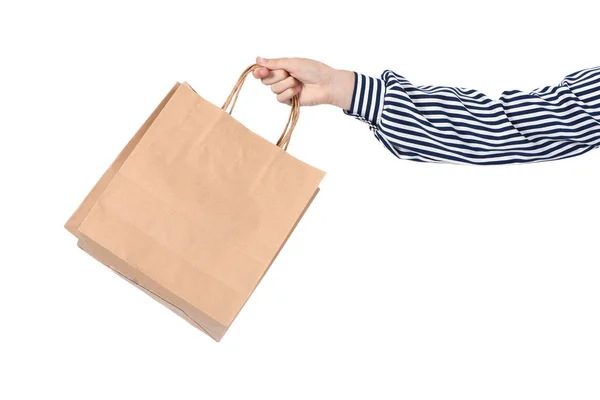 Dětská ruka drží papírové nákupní tašky izolované na bílém — Stock fotografie