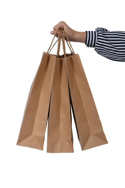 Criança mão segurando sacos de compras de papel isolado no branco — Fotografia de Stock