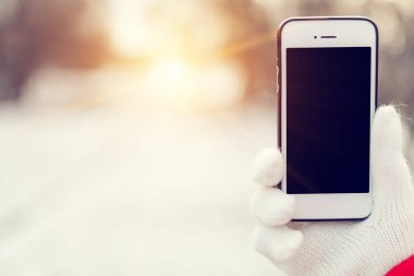 bir kız kalça üzerinde bir cep telefonu arka plan üzerinde bir kış street alır