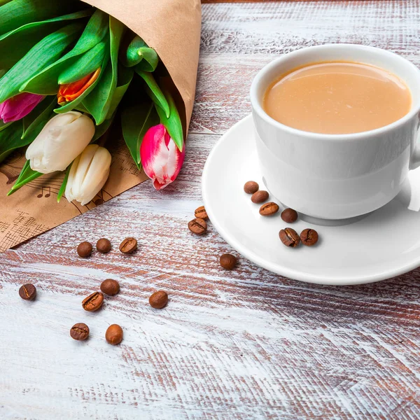 Tulpaner och kaffe isolerad på ett träbord — Stockfoto