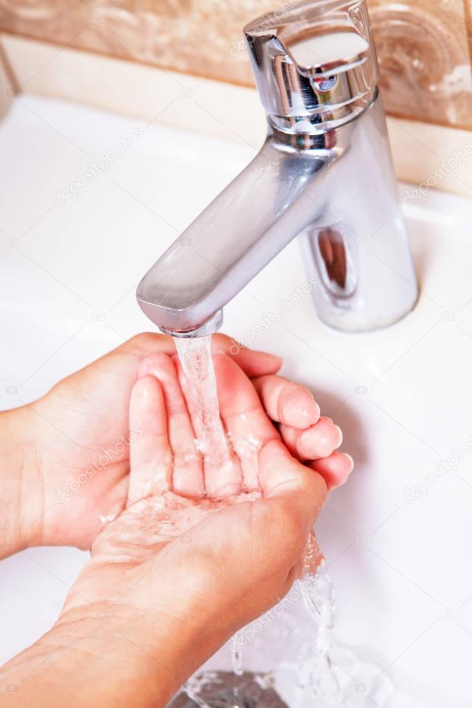 Washing hands under tap water