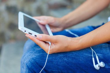 Bir tablet ellerde ile oturan kız