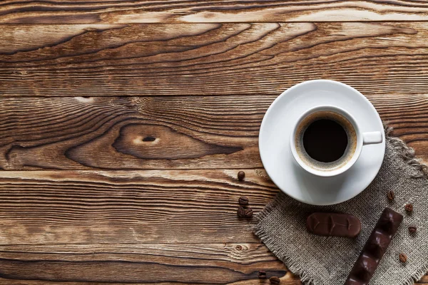 Ágynemű és a csésze kávét a háttér egy fából készült t pitét — Stock Fotó