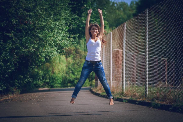 Kız bir asfalt üzerinde atlama — Stok fotoğraf