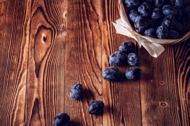 bir ahşap zemin üzerinde mavi Erik döktüm