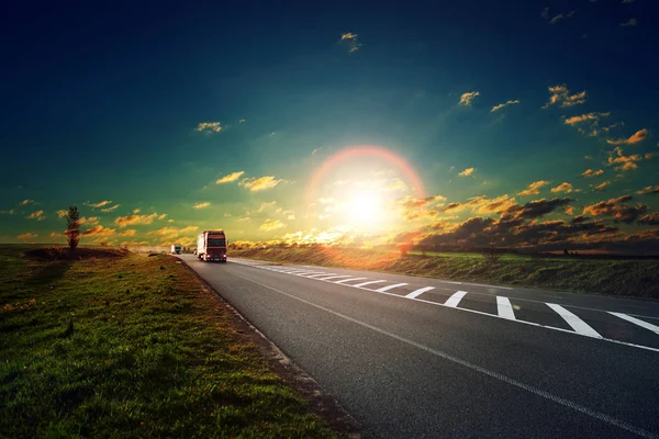Günbatımında bir karayolu üzerinde birçok kamyon