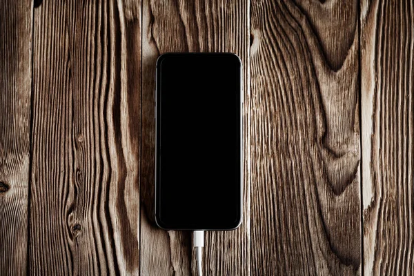 Смартфон на дерев'яному столі — стокове фото