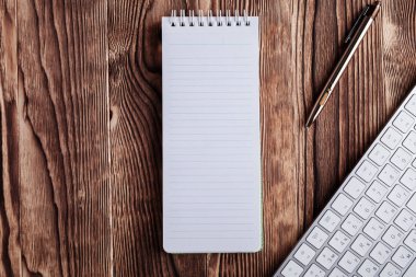 Beyaz: Not defteri ve bilgisayar tuş takımı ahşap masaüstü