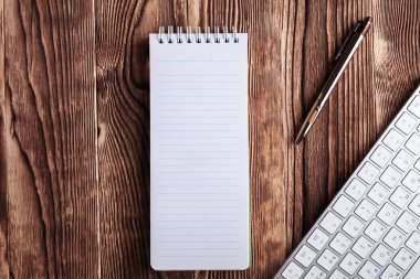 Beyaz: Not defteri ve bilgisayar tuş takımı ahşap masaüstü