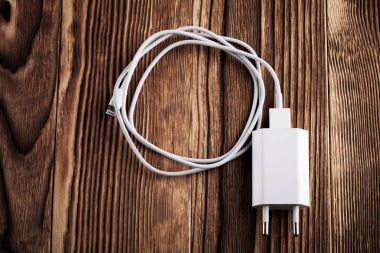 Cable phone charger on wood background clipart