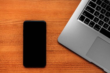 Smartphone ve masa üstünde laptop