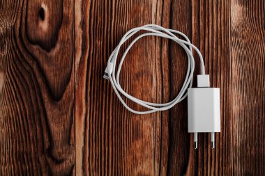 Ahşap arka planda kablo telefon şarj cihazları