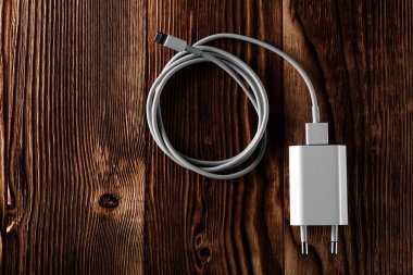 Ahşap arka planda kablo telefon şarj cihazları