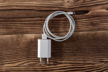 Ahşap arka planda kablo telefon şarj cihazları