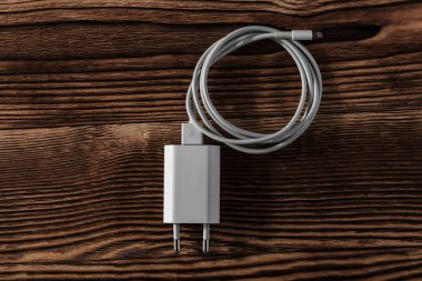 Ahşap arka planda kablo telefon şarj cihazları