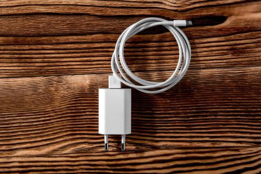 Ahşap arka planda kablo telefon şarj cihazları