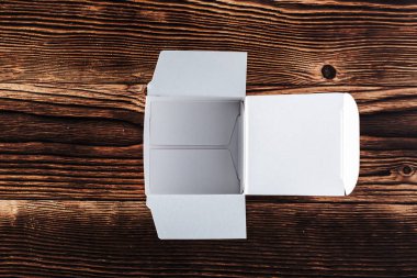 Ahşap arka plan üzerinde beyaz karton kutu