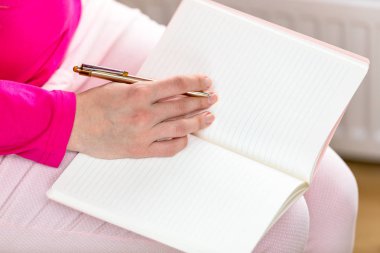 Kadın kağıt not defterinde yazıyor