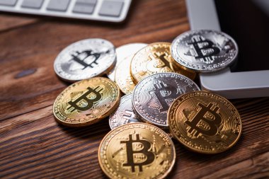 Ahşap masa üzerinde modern cep telefonunda altın Bitcoin
