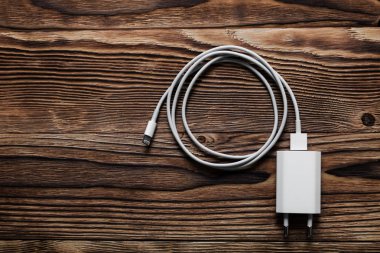 Ahşap arka planda kablo telefon şarj cihazları
