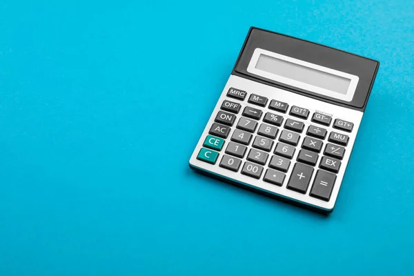 Calculator en vergrootglas op blauwe achtergrond. — Stockfoto