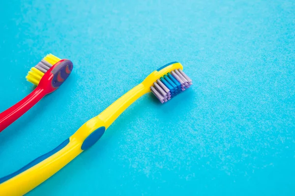 Концепция чистки зубов. Зубные щетки на синем фоне — стоковое фото