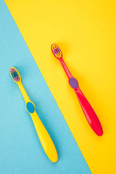 Teeth brushing concept. Toothbrushes on a yellow and blue backgr — Stock Photo, Image