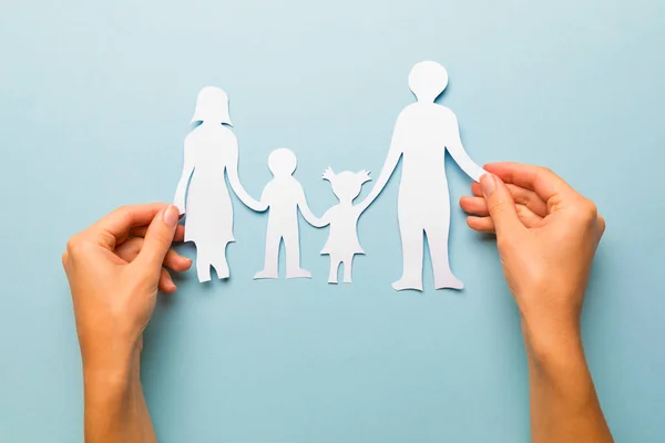 Familia de papel en mano aislada sobre fondo azul — Foto de Stock