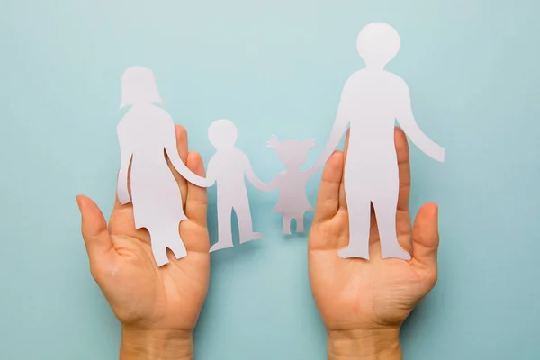 Familia de papel en mano aislada sobre fondo azul — Foto de Stock