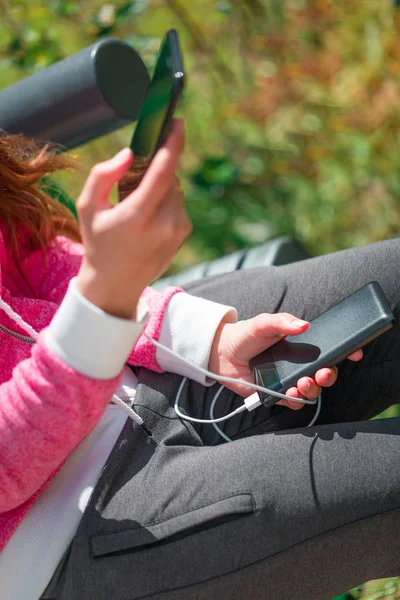 Donna mani in possesso di smartphone nero batteria di ricarica da esterno — Foto Stock