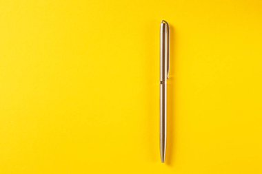 Sarı arkaplanda metal kalem izole edildi