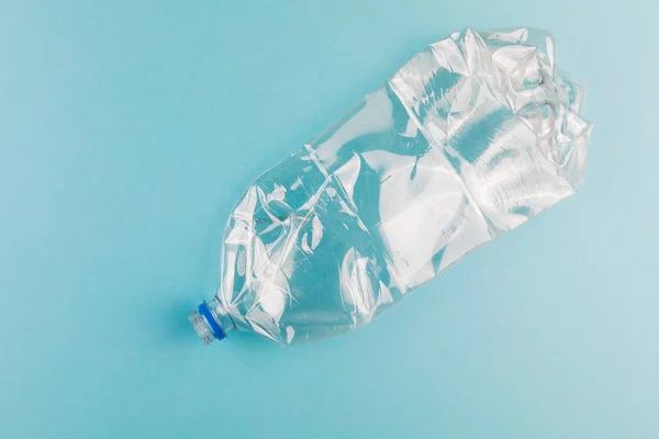 Gekromde plastic flessen op een blauwe achtergrond. Kunststof afval. — Stockfoto